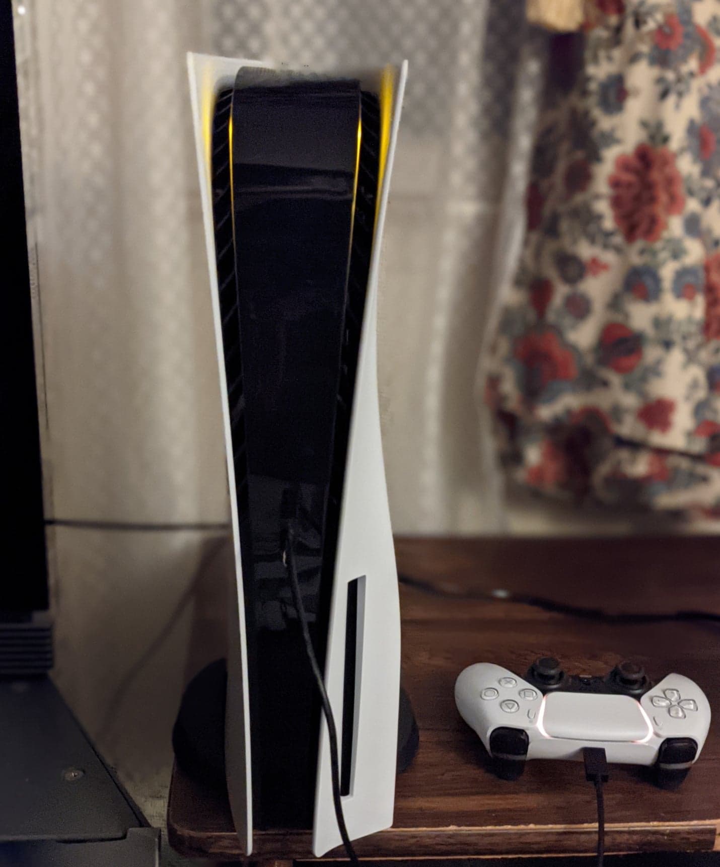 Consola PlayStation 5 blanca con un control DualSense sobre una mesa; fotografía de 2020.