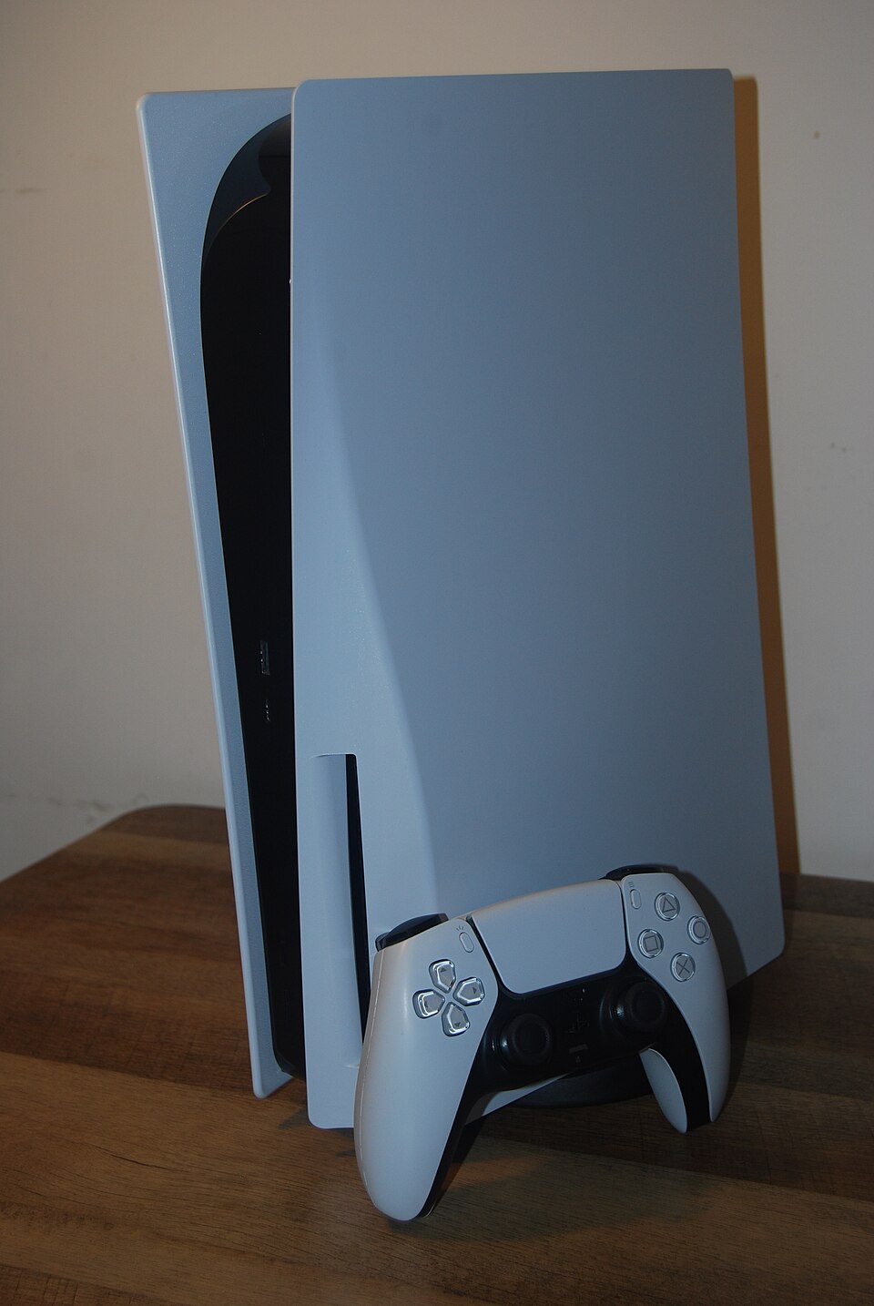 Una consola PlayStation 5 blanca y su control DualSense sobre una mesa de madera; fotografía referencial de la plataforma tomada el 3 de julio de 2023.